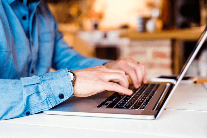 man typing on laptop