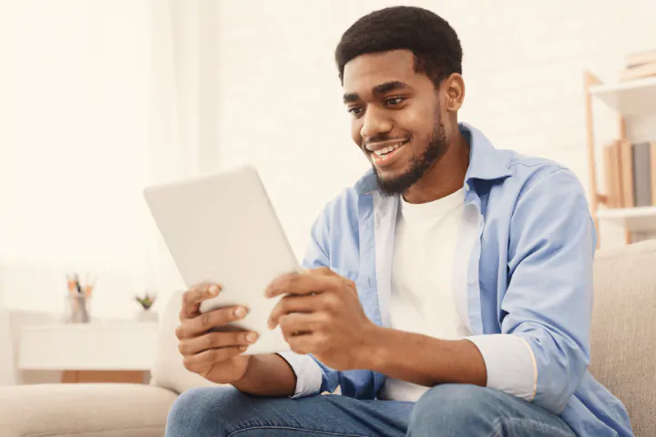 man using tablet in living room