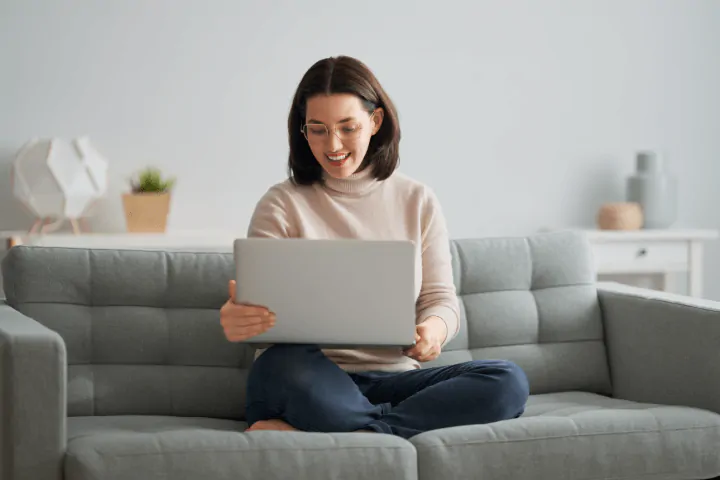 woman using laptop on sofa
