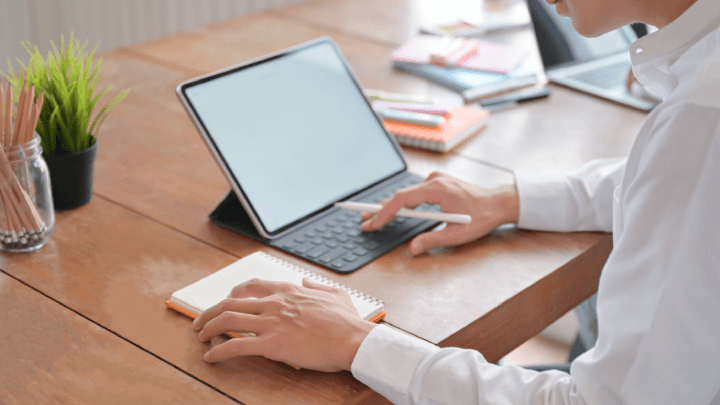 man using tablet computer and notepad