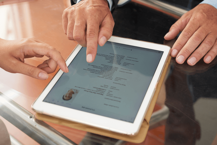 reviewing digital project manager resume on tablet