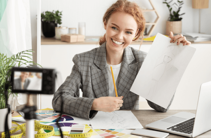 woman holding up sketch to camera