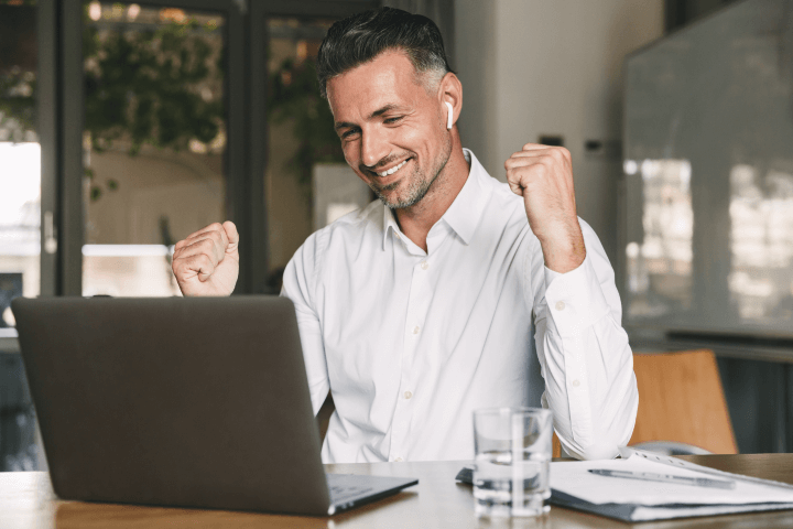 man celebrating in front of laptop