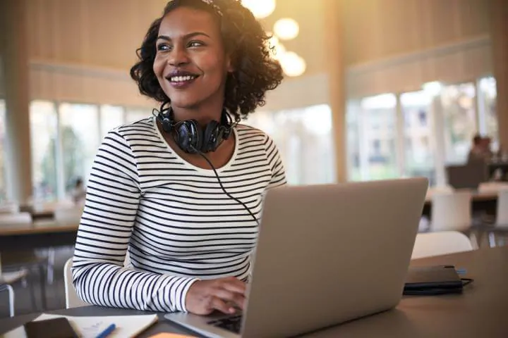 wanita tersenyum saat menggunakan laptop untuk pembelajaran sosial