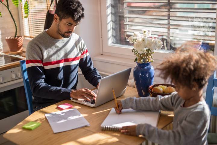 man works from home with his son