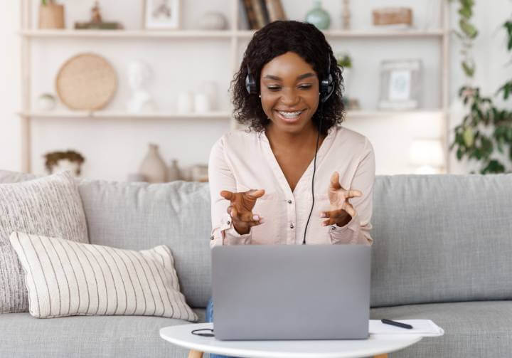 happy woman with headphones on video conference