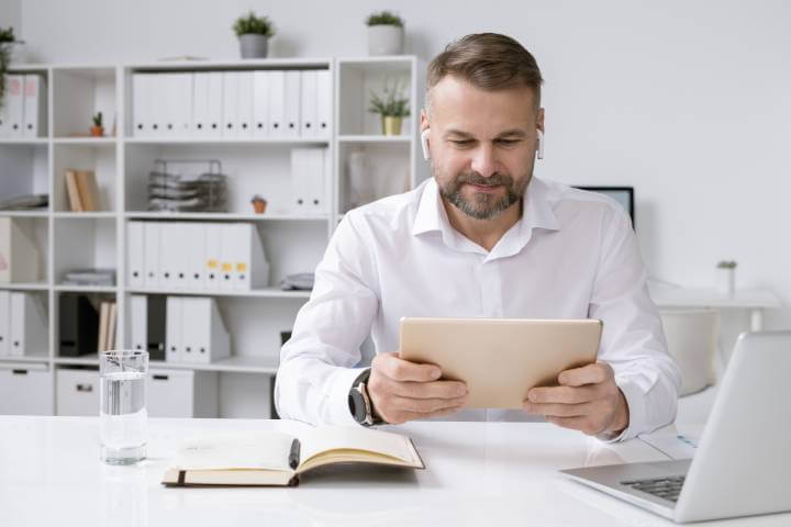 man using tablet and wireless headphones 