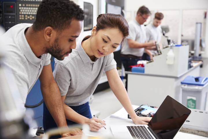 woman and employee look at computer screen 