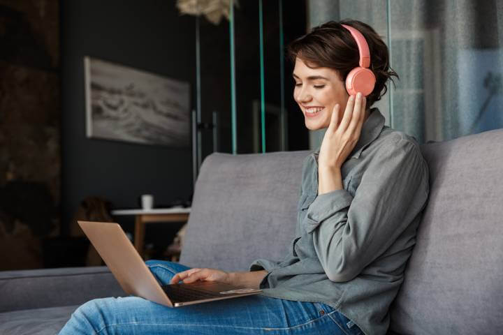 woman using laptop with headphone to learn online