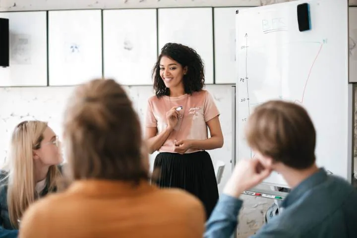 woman training staff using whiteboard