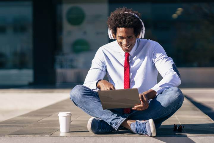 man learning asynchronously on laptop outdoors