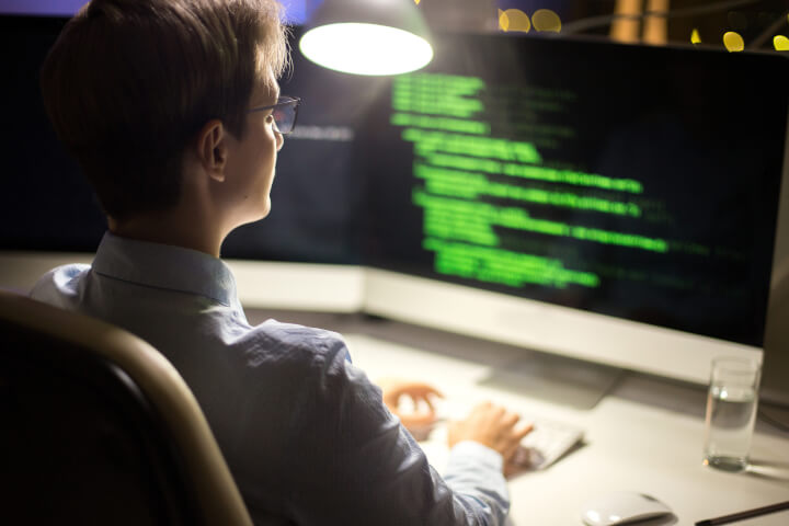 man coding as part of his cyber security skills