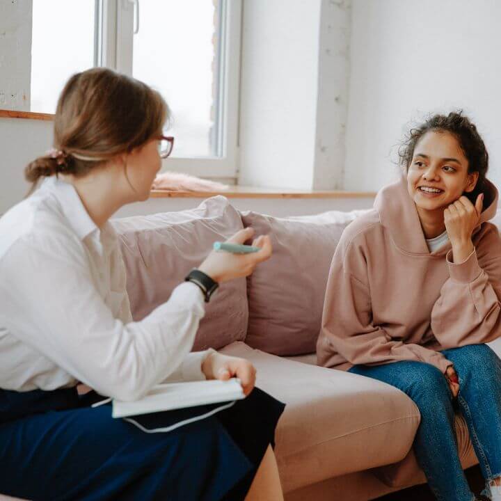 two women colleagues talking on the couch