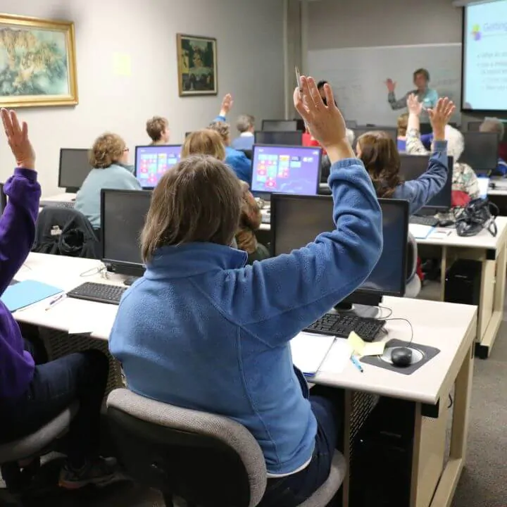 employees raising hands in a training session