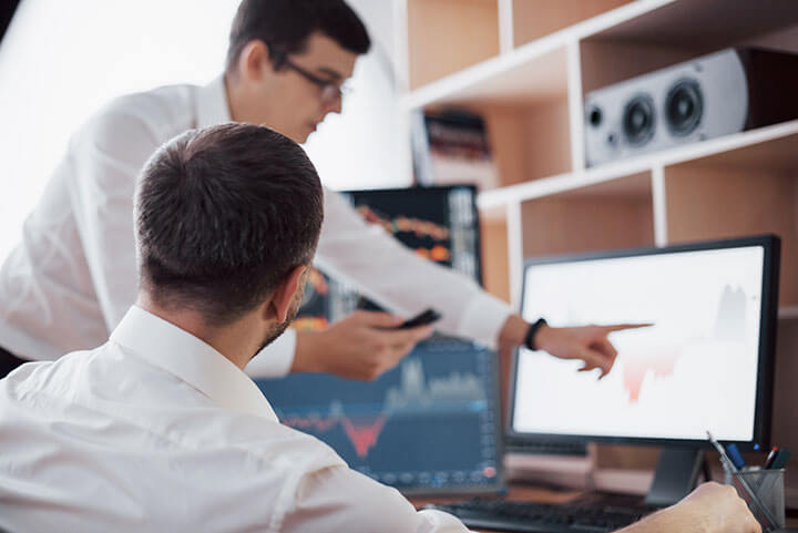 Man training a staff member using a PC